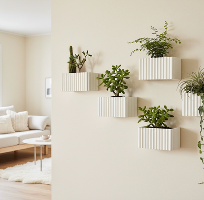 White wall-mounted planters with green plants in a living room setting.