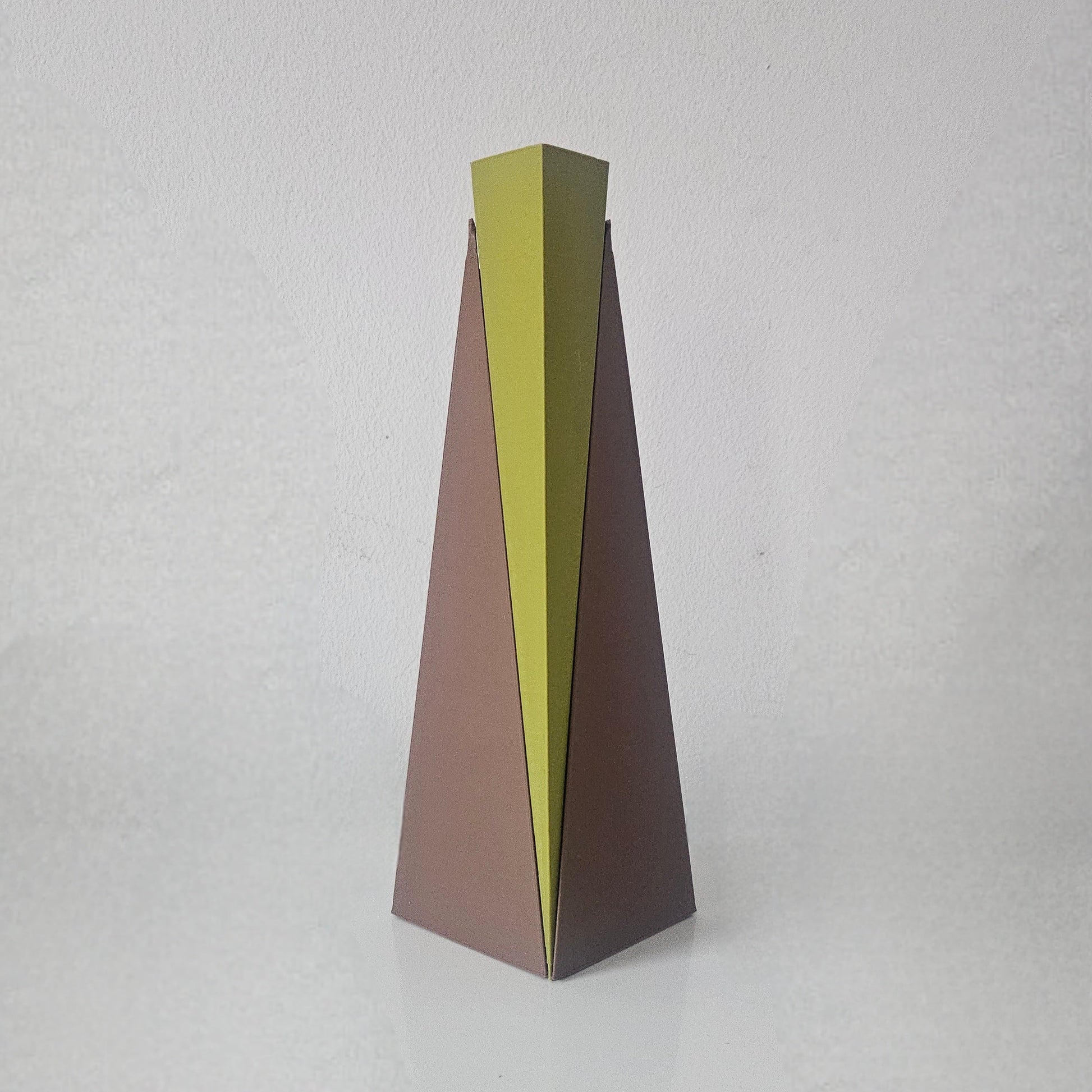 Tall, thin vase with a gradient color from green to brown on a light gray background